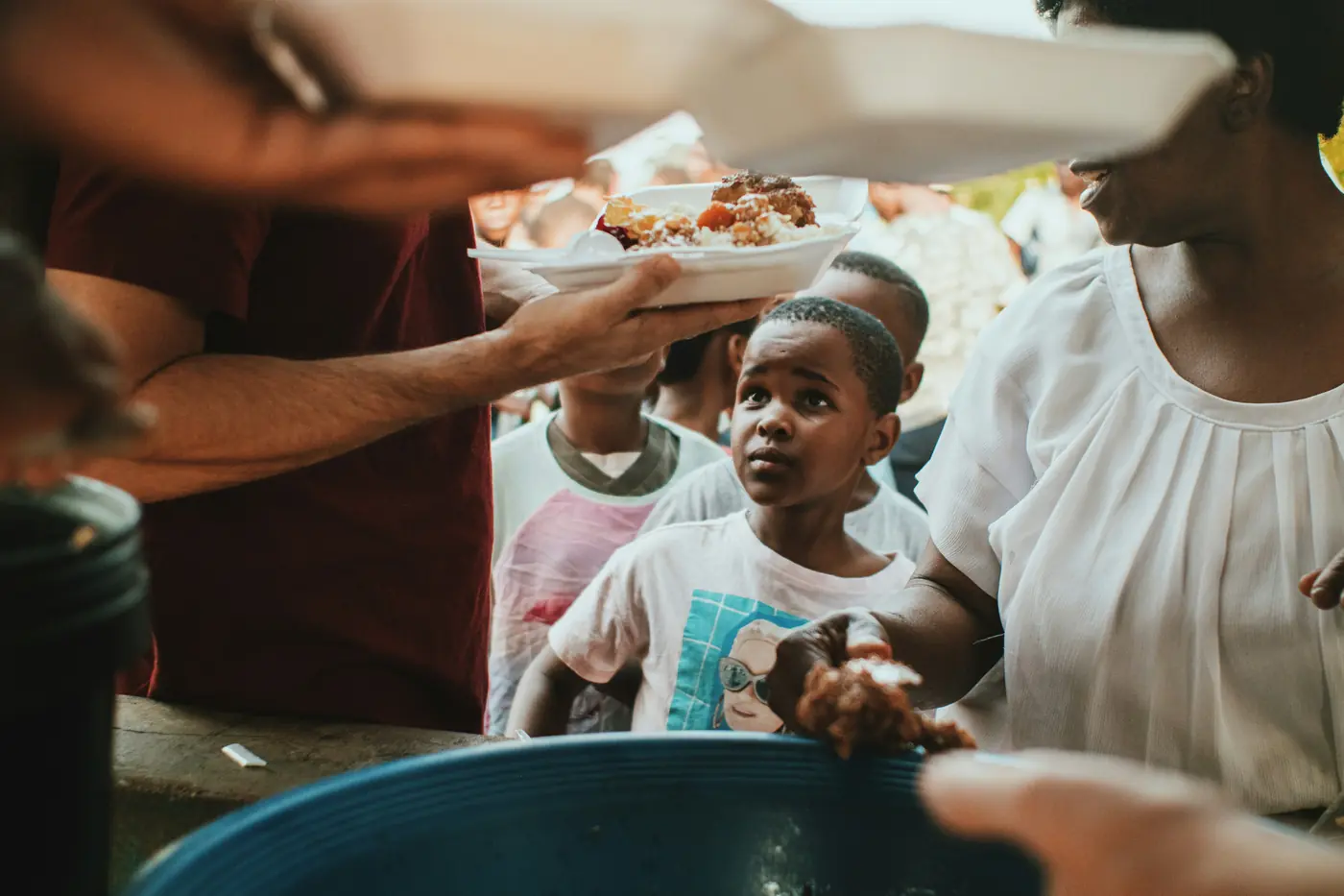 Hands passing plates of food at a community meal