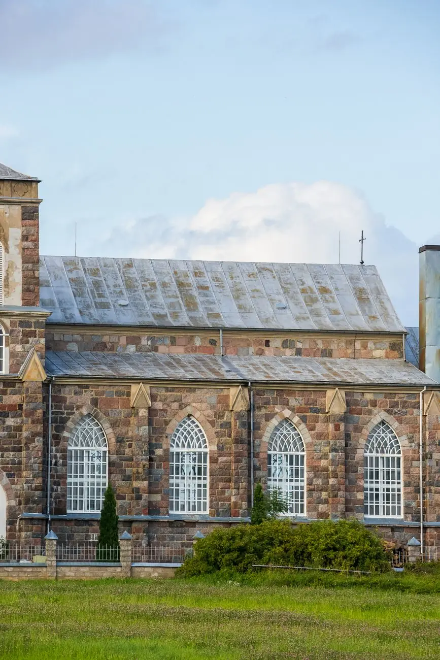 The stone facade and arched windows of St Joseph's Church against a blue sky