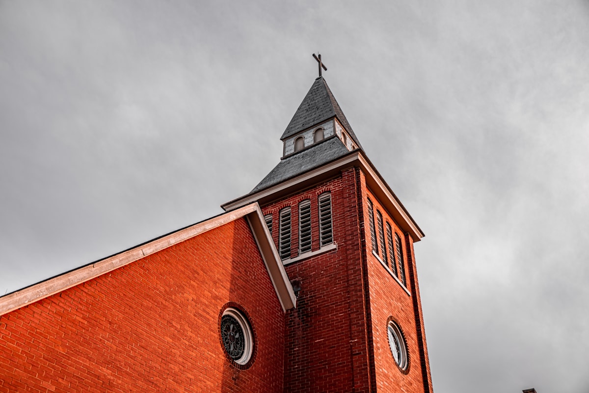 A historic brick Catholic church with a steeple